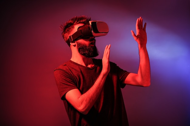 Man wearing virtual reality glasses on dark color