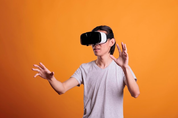 Uomo che indossa l'auricolare vr che gioca a giochi di realtà virtuale, esplorando il metaverso. persona con occhiali ar che si diverte con videogiochi, esperienza di simulazione, intrattenimento nel cyberspazio, stile di vita moderno