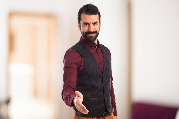 Man wearing waistcoat making a deal on unfocused background