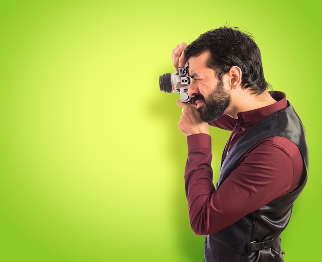 Foto uomo che indossa il panciotto fotografare su sfondo colorato