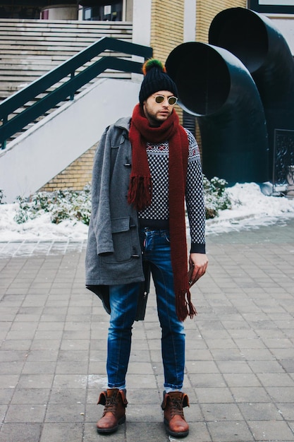 Man wearing warm clothing standing on footpath outdoors