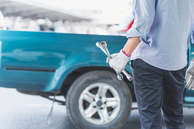 Photo a man wearing white gloves and holding cross wrench