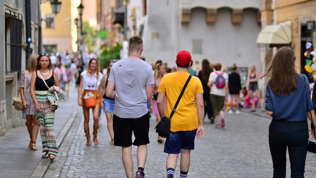 A man wearing a yellow shirt is walking down a street with a woman