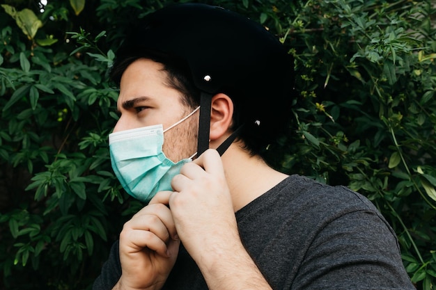 Man wears a bike helmet with a medical mask to be safe