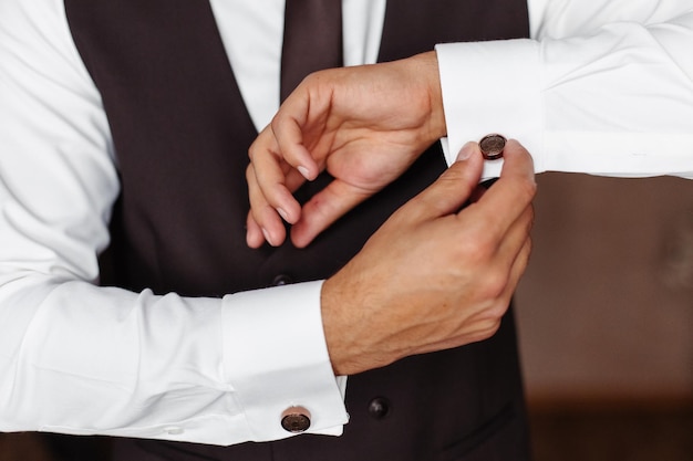 The man wears cufflinks.