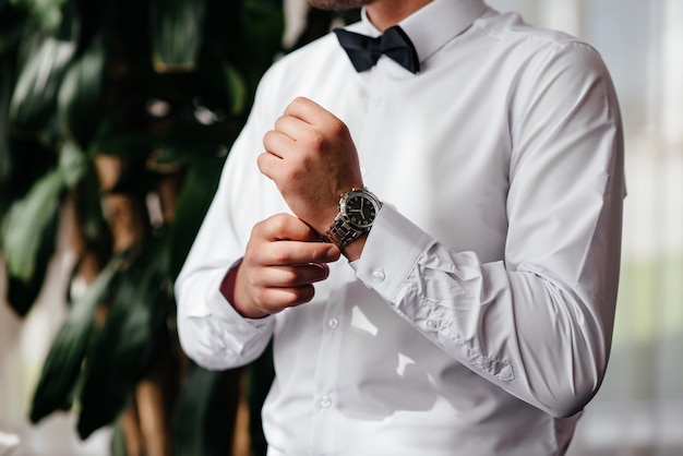 A man wears a watch on his hand