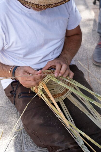 Foto man weeft een kanarie wicker mand