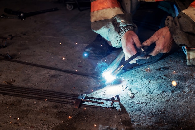 Man welding in garage  Manual welding, sparks, iron 