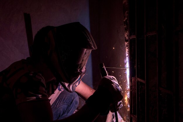 a man welding a gate knob inside