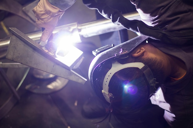 写真 工場で金属を溶接する男