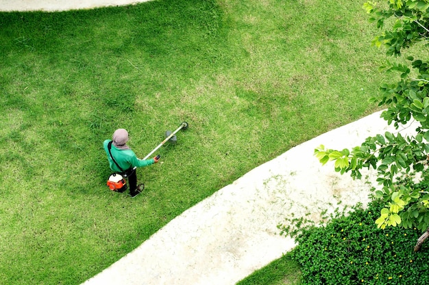 Man werknemer gras maaien met grasmaaier