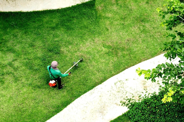Man werknemer gras maaien met grasmaaier