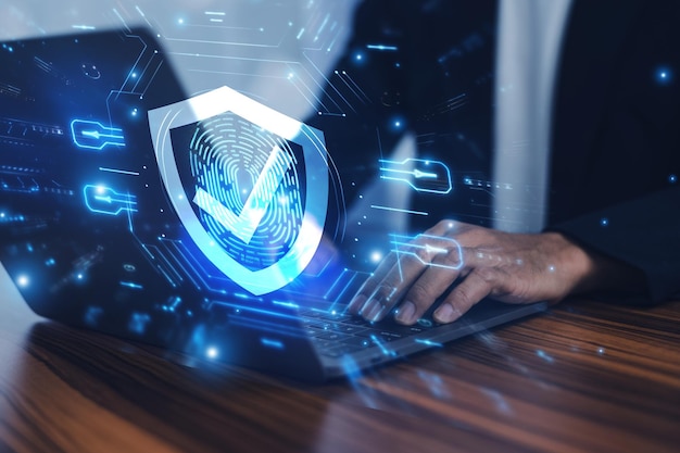 Man werkt aan een laptop met een geavanceerd cybersecurity schild dat de bescherming van gevoelige gegevens en de beveiliging van de digitale omgeving tegen potentiële bedreigingen garandeert