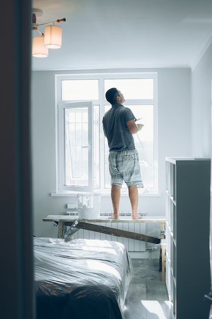 Man werkt in de kamer, maakt reparaties. Onvoltooide appartement interieur. Reparaties in het appartement.