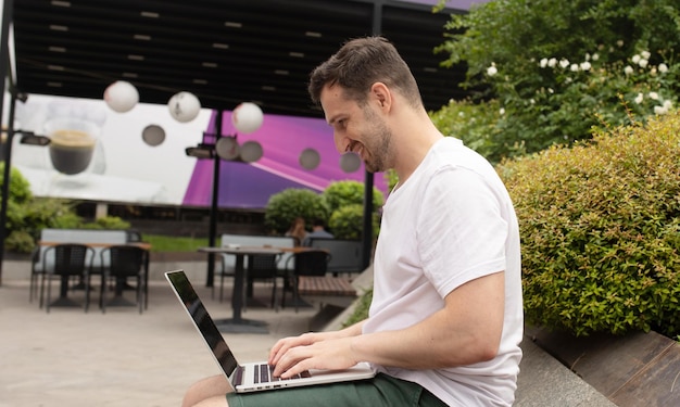 Man werkt met laptop pc computer rust ontspannen in het stadspark buiten op de natuur