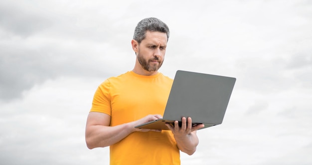 Man werkt online op computer op de achtergrond van de lucht