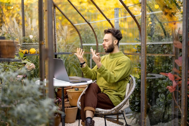 Man werkt op afstand op laptop in tuin