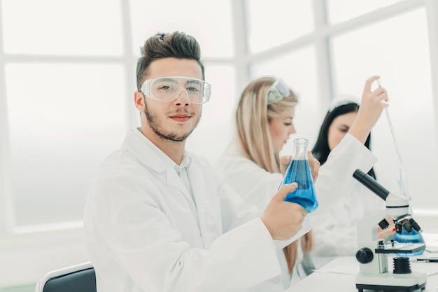 Man wetenschapper met een kolf met vloeistof voor het experiment