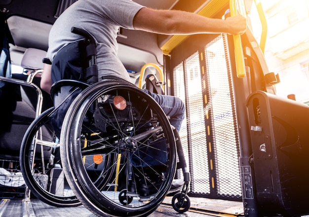 A man in a wheelchair inside of a specialized vehicle with a\
lift for people with disabilities.