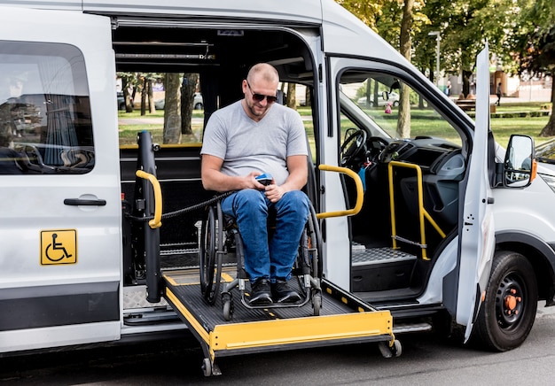 Foto un uomo su una sedia a rotelle su un ascensore di un veicolo per persone con disabilità