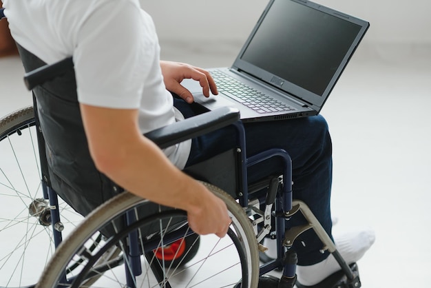 Man in wheelchair working on laptop in living room