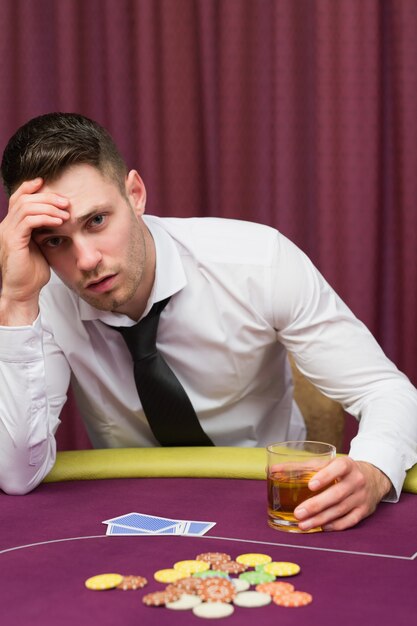 Man whisky drinken aan pokertafel