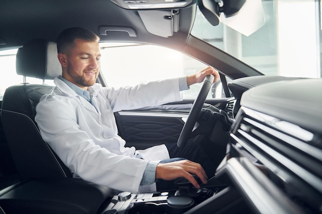 L'uomo in camice bianco guida l'auto