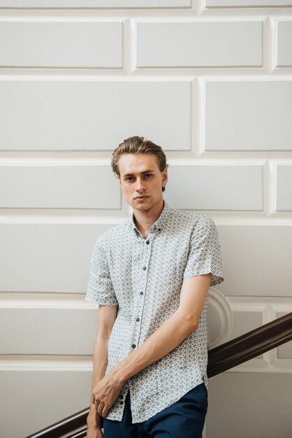 A man in a white plaid shirt and blue trousers poses for advertising men's clothing. Shooting for men's clothing store