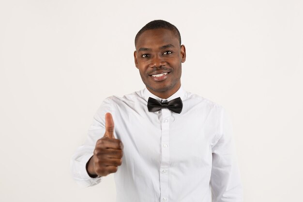 man in white shirt and bow tie with hand gesture