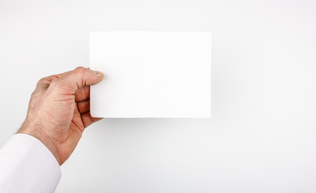 A man in a white shirt holds a blank blank on an isolated background Blank flyer businessman or doctor holds in his hand