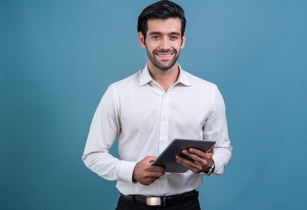 A man in a white shirt holds a tablet in front of a blue background.