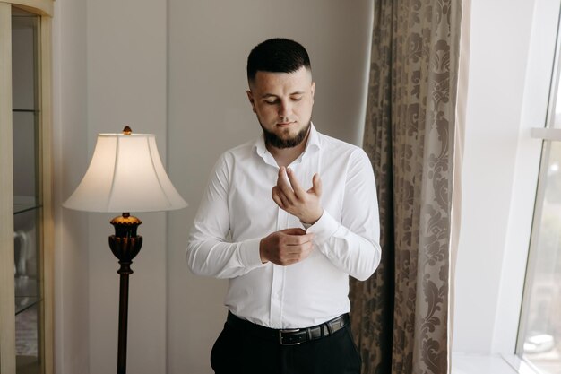 Photo a man in a white shirt is standing in front of a lamp