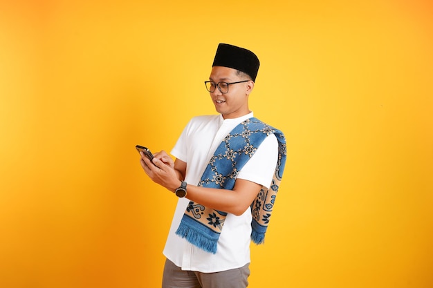 A man in a white shirt is texting on his phone