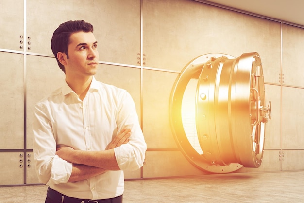 Man in white shirt near open vault on a sunny day