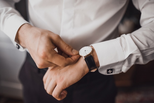 man in a white shirt straightens his watch