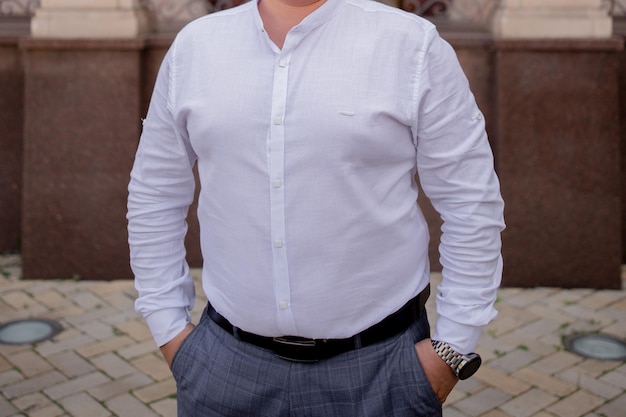 A man in a white shirt on the street near a building