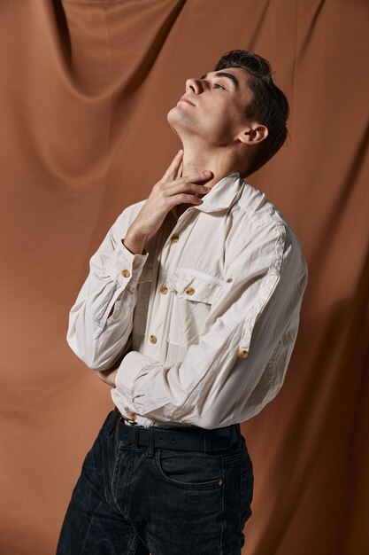 Man in white shirt studio modern lifestyle brown background