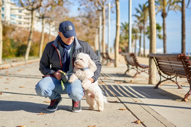 Man white small dog walk park