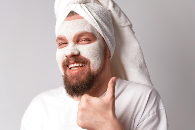 Man in white tshirt apply facial mask stand against white background Self care morning spa procedure