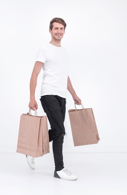 Man in a white Tshirt carries a bunch of shopping bags white background