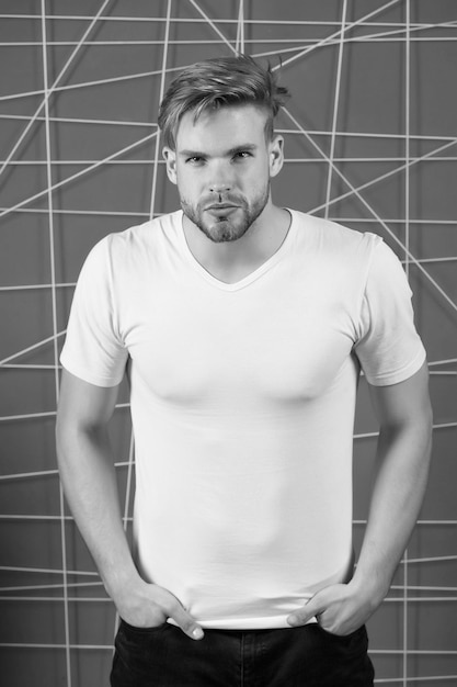 Man in the white tshirt with copy space standing on pink wall background