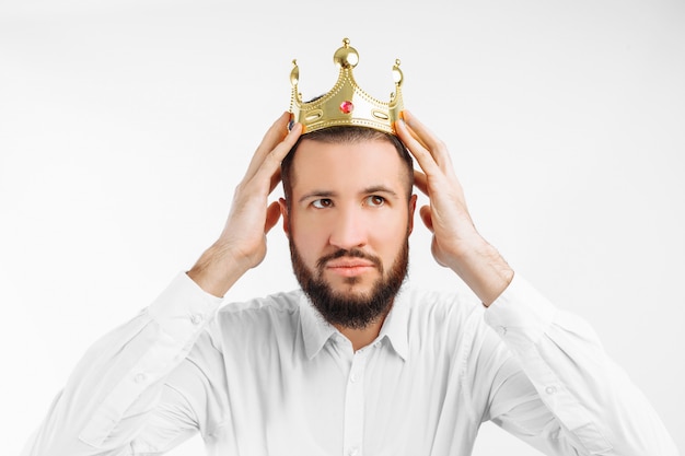 A man on a white wall, wears a crown on his head, 