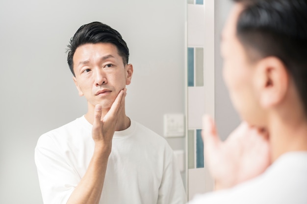 A man who looks in the mirror and checks the condition of his skin