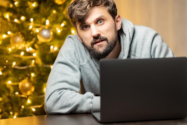 A man who works on New Year's Eve bowed down in front of a laptop tired from work