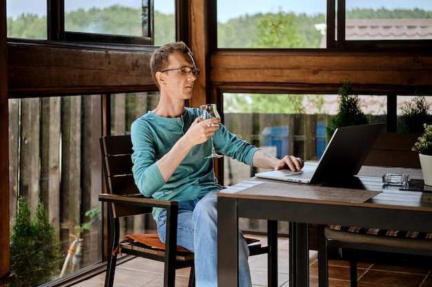 Foto man wijn drinken en chatten in messenger op laptop