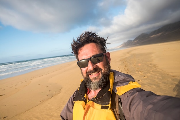 Man in the wild nature at the beach doing selfie picture