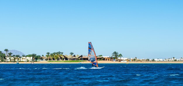 Uomo che fa windsurf in mare contro un cielo limpido