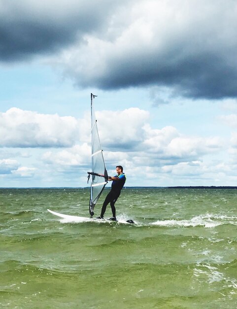 Foto man windsurft op zee tegen de lucht