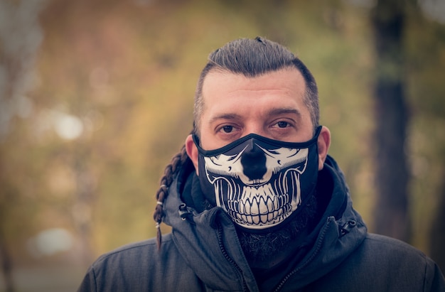 医療用フェイスマスクを着用した路上で冬服を着た男。感染から保護するための呼吸器の男性
