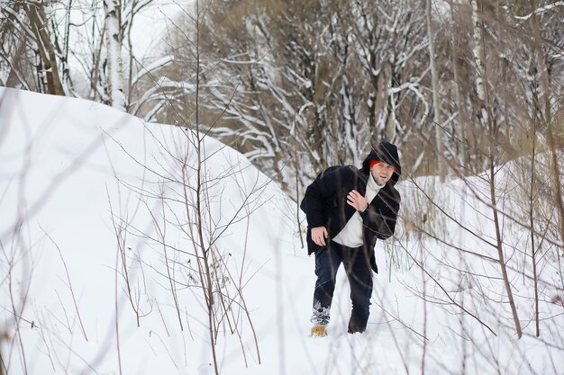 A man in the winter in the forest. A tourist with a backpack goes through the woods in winter. Winter ascent.